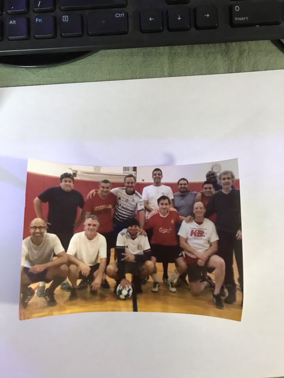 A group of soccer players posing in a gym